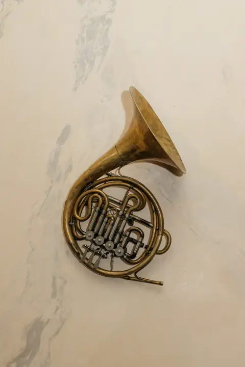 Brass French horn on the marble wall of the restaurant