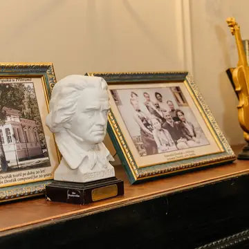 A bust of Antonín Dvořák and period photographs in the restaurant’s museum exhibition
