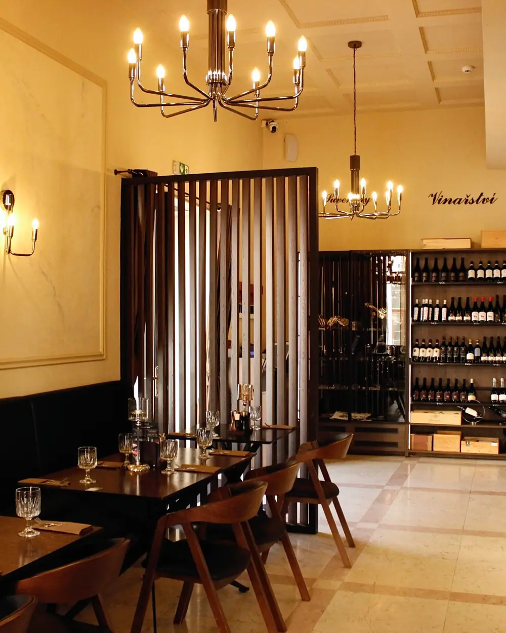 The restaurant’s interior with chandeliers, the wine cabinet and laid tables