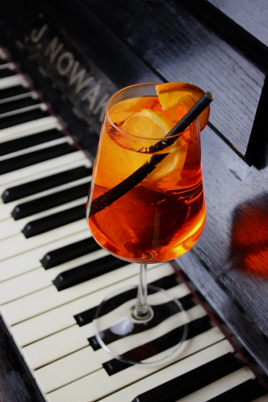 Koktejl Aperol Spritz na klávesách pianina J. Nowak