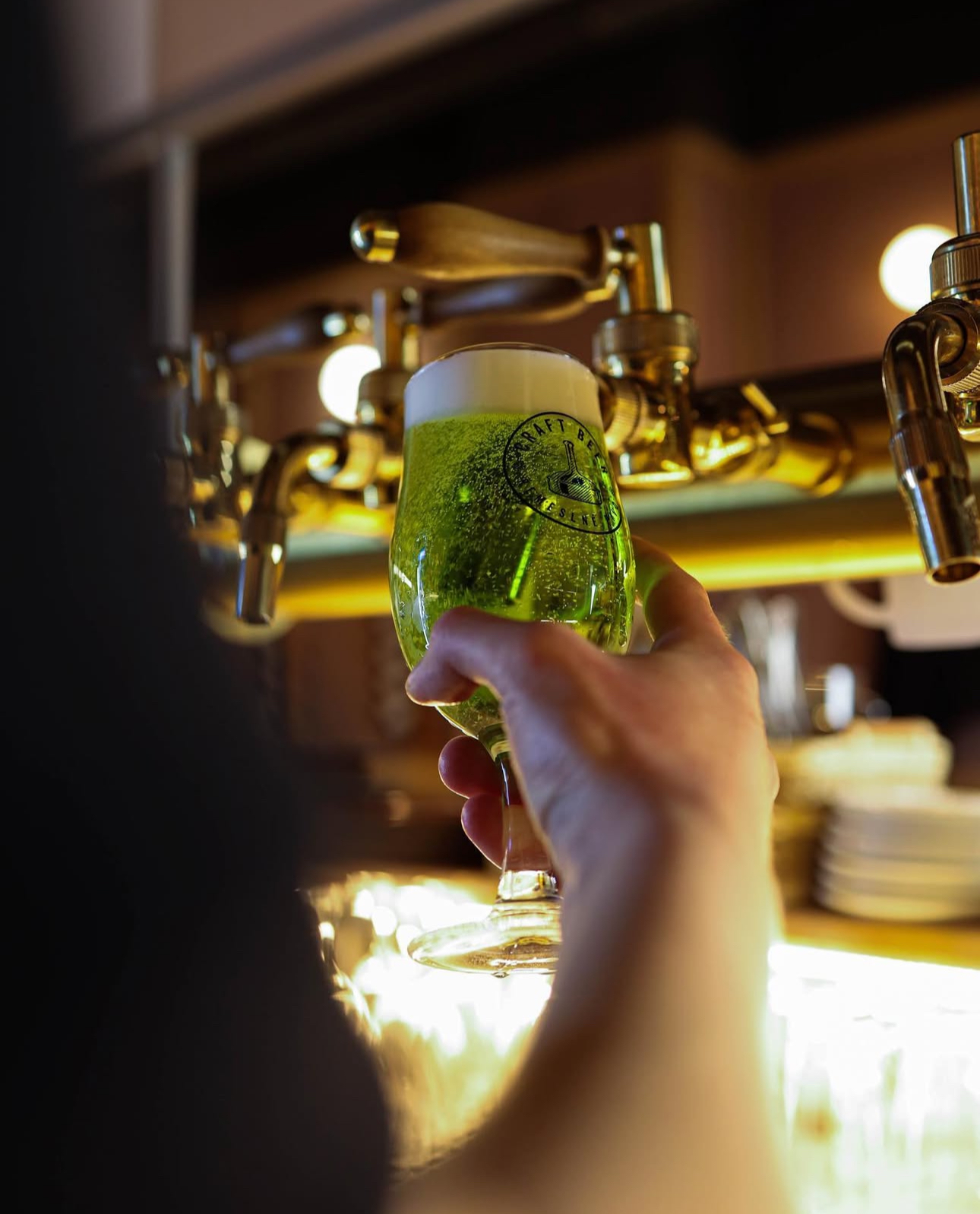A glass of refreshing green beer with a rich head, served at the A. Dvořák restaurant