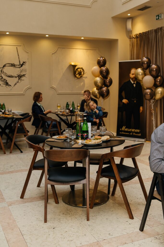 Interiér pivovarské restaurace A. Dvořák Praha během oficiálního otevření, hosté si užívají slavnostní atmosféru.