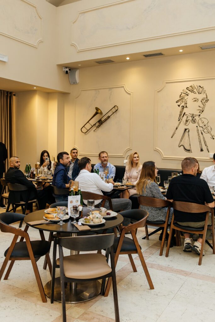 Hosté sledují hudební program během slavnostního otevření pivovarské restaurace A. Dvořák Praha.