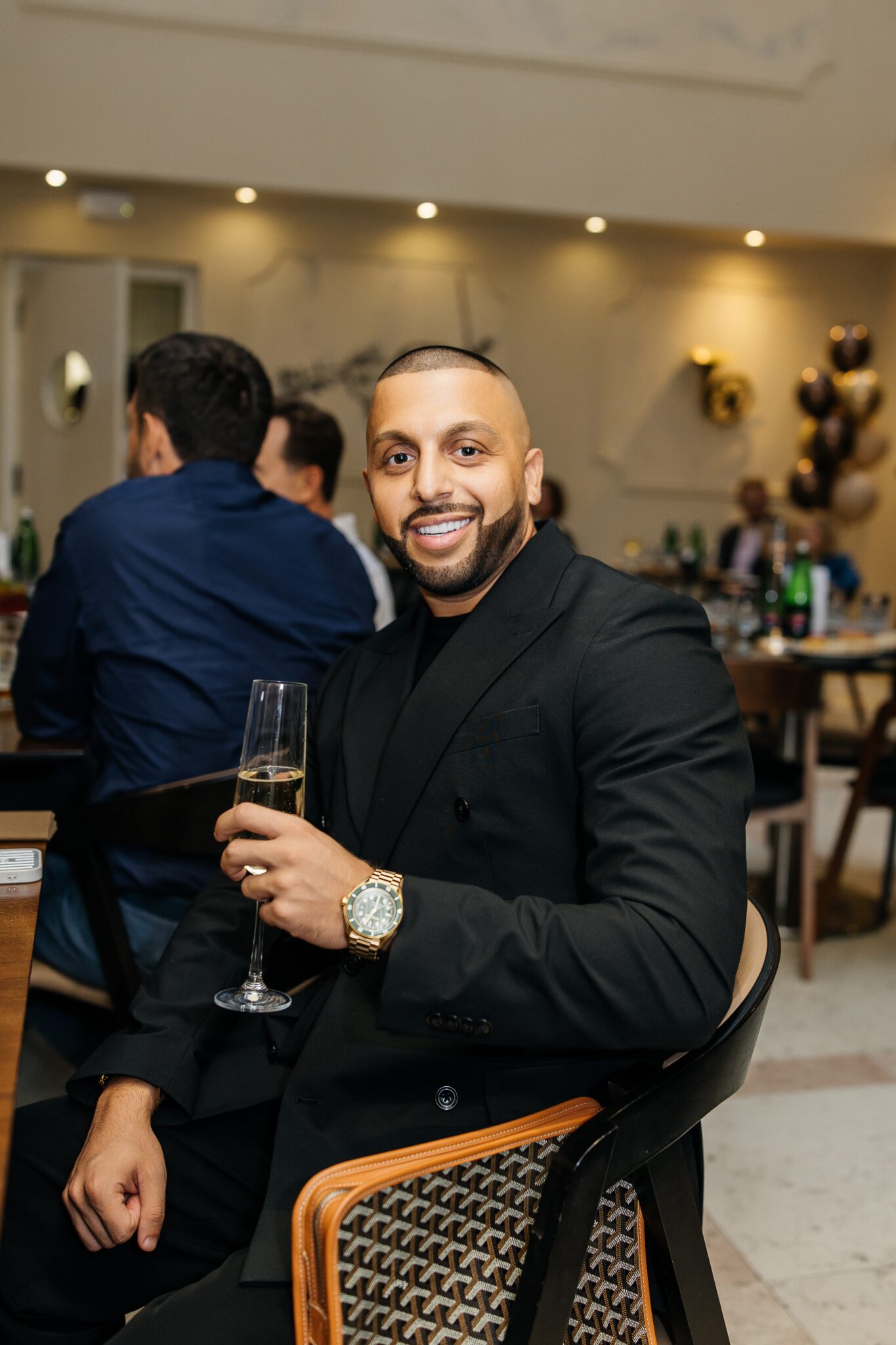 A guest enjoying a glass of champagne during the grand opening of the A. Dvořák brewery restaurant in Prague.